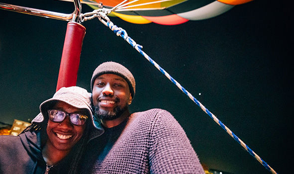 Two students smiling in a hot air balloon