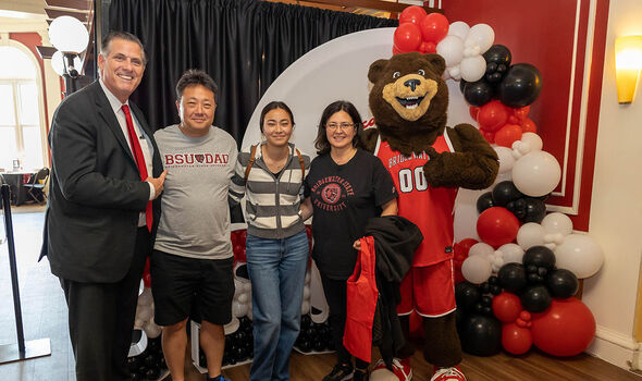 A BSU student and her parents pose with Bristaco and President Clark