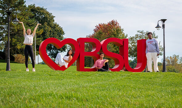 Four students posing with the I Heart BSU sign on a sunny fall day