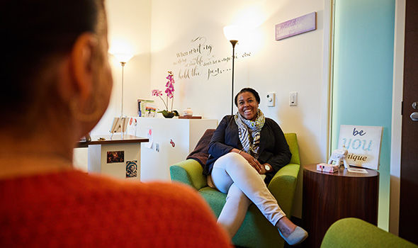 A counselor smiles as she speaks with a student in a private session