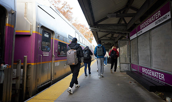 A group of commuters leave the train on the MBTA platform