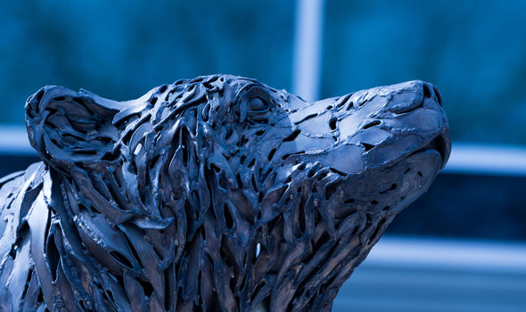 Close-up of the bronze bear sculpture in front of Rondileau Student Union - the bear's face looks up toward the sky and to the right