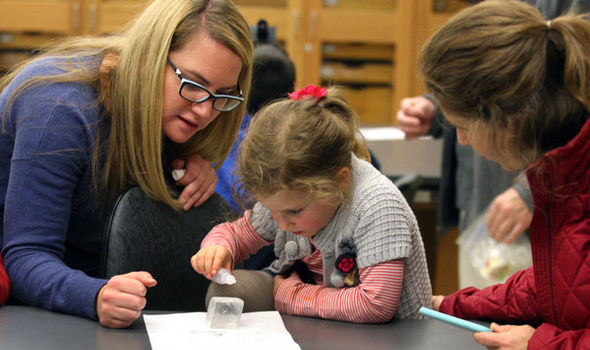 BSU student helps elementary school student with an experiment