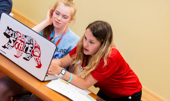 Orientation Leader helping new student on computer