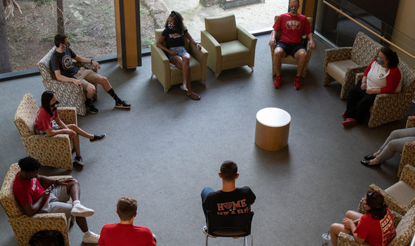 students sitting in a circle in club chairs in the DMF Science and Math Center