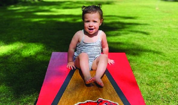 child sitting on a Bridgewater State University corn hole set