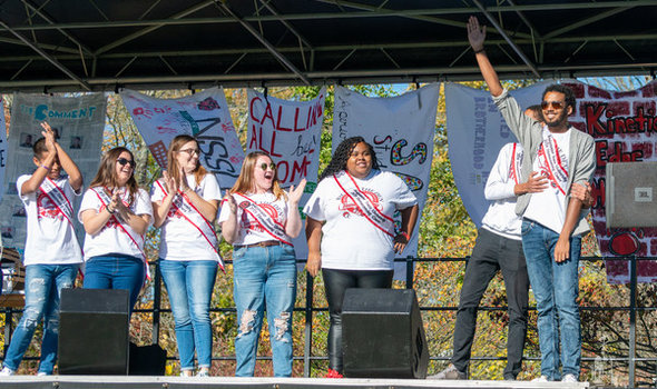 2019 Homecoming court on stage smiling and clapping