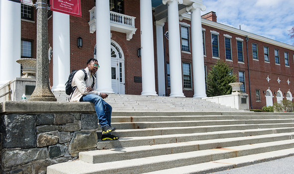 A student sitting on the steps of Boyden Hall