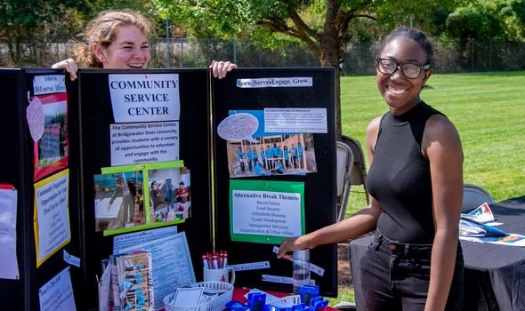 two students at an info table about the Community Service Center