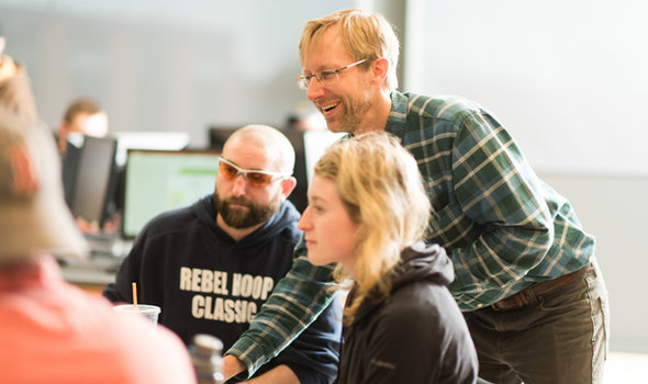 Dr. Rob Hellstrom helping 2 students while teaching Cartography class
