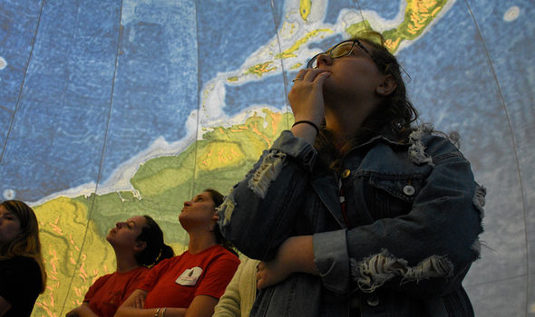 High school students touring the inside of an Earthview globe