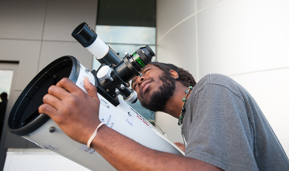 A student using a telescope at the BSU Observatory