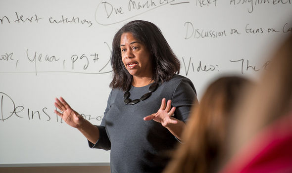 Dr. Mia Ortiz teaching class in front of a white board with Criminal Justice class notes on it