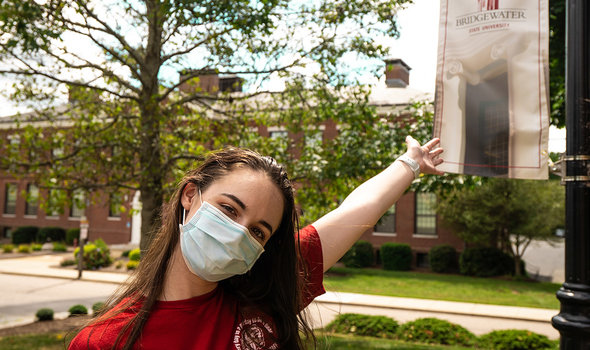 A member of the orientation team gestures to a BSU flag