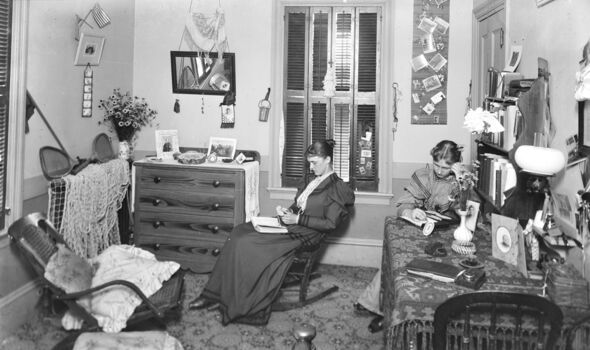 A historic photo of two students studying in a dorm room