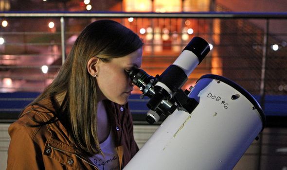 woman looking into a telescope