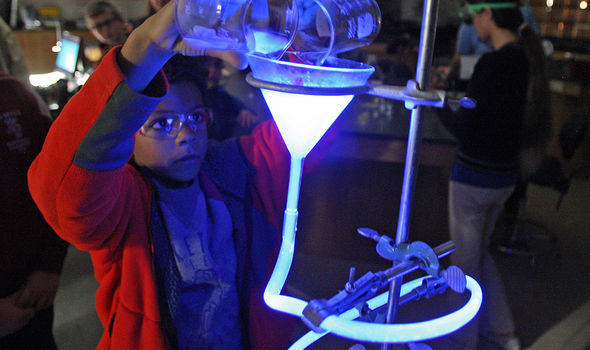 A boy mixing glow in the dark solutions at Open Lab Night