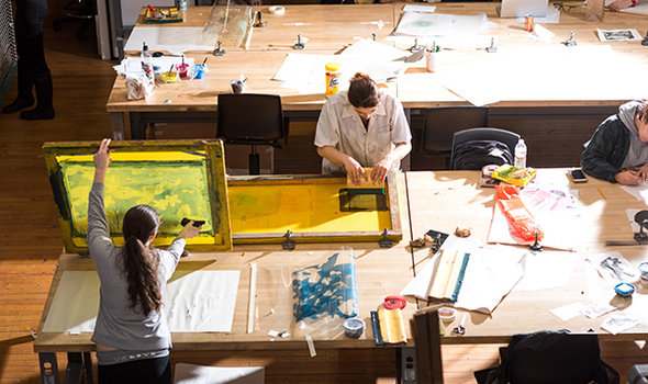 students making prints on large tables with screens attached to them