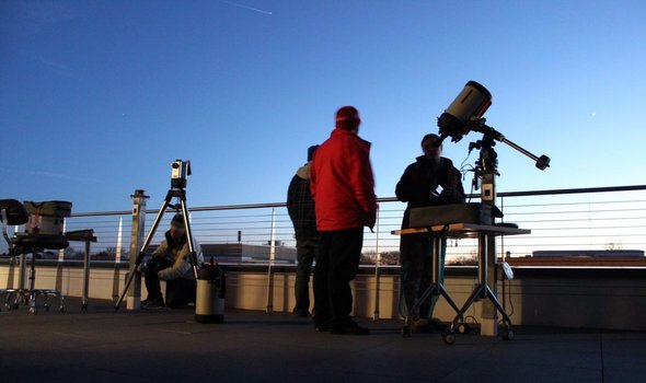 people and telescopes on observatory deck