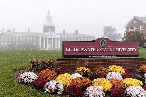 2022.20.25-fall-fog-au-05-cta.jpg The Bridgewater State University sign on Boyden Quad with fresh fall mums; Boyden Hall is in the fog in the background