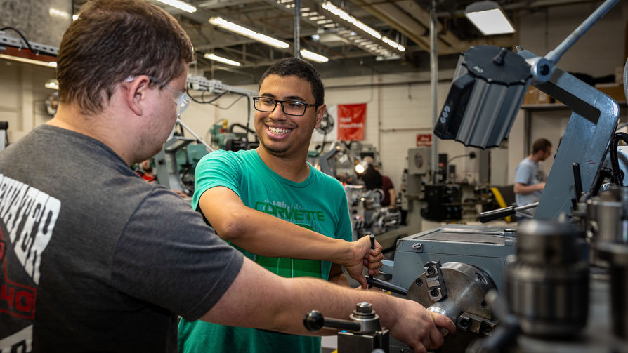 2 students working with equipment in a machine shop at South Shore Regional Voc Tech High School