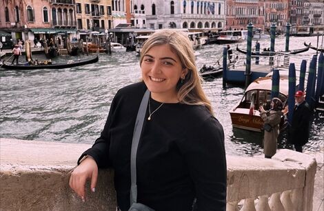 A woman stands and smiles at the camera 