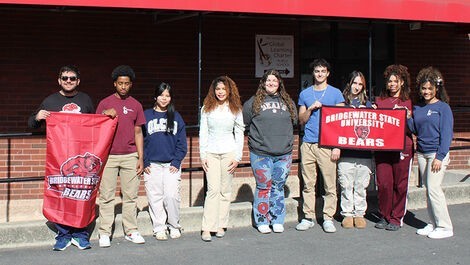 Several students stand in a line while holding BSU banners.