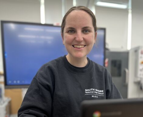 A woman wearing a black shirt smiles at the camera 