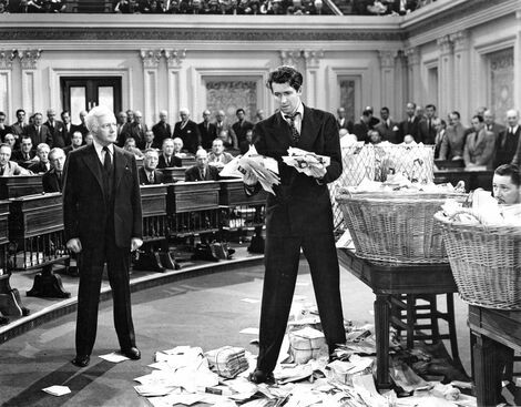 Promotional still from the 1939 film Mr. Smith Goes to Washington showing James Stewart holding piles of letters on the floor of the Senate