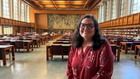 Fernanda Ferreira stands in a large library room.