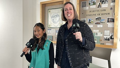 Mary-Jane Storm stands with a girl while both hold microphones