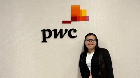 Glendys Bonilla stands next to the PwC logo.