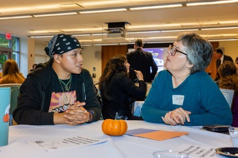 Two people sit at a table and talk to each other 