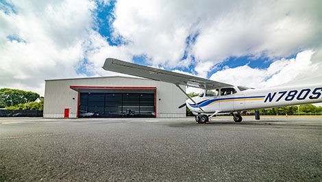 A new hangar with an airplane in the foreground.