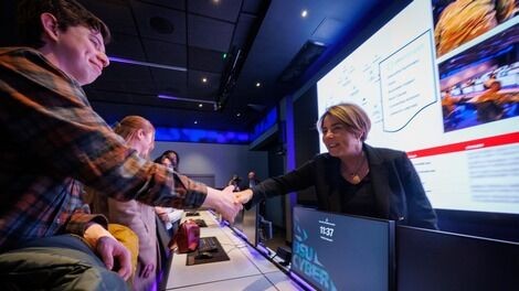 Maura Healey shakes hands with a student in the cyber range.