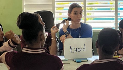 Megan Lenza teaches young students the English word “braid.”