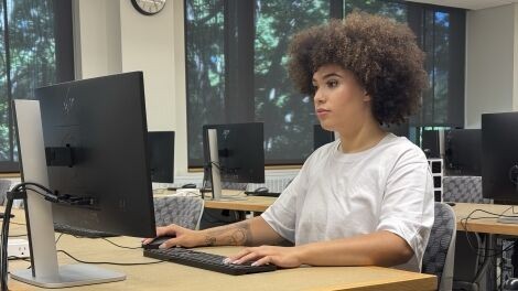 A student works at a computer in a computer lab.