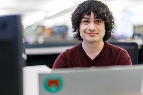 A young man smiles at the camera 