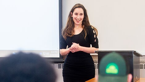 Sidita Kushi teaches a class in front of a white board.