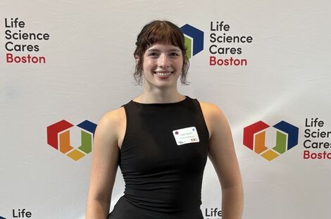 A woman wearing a black dress smiles 