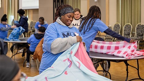 Students fold blankets as part of a service project.