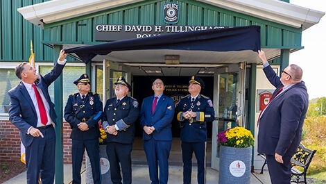 Dignitaries unveil the David Tillinghast Police Station sign.