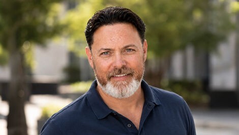 Headshot of Weston Smith in front of a street lined with trees