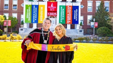 Haley March and President Clark pose for a photo in front of Boyden Hall.