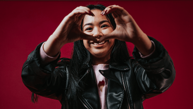 Venussa holds up her hands in front of her face in the shape of a heart