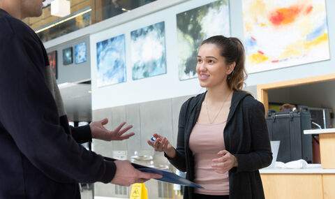 2 people talking and exchanging written information