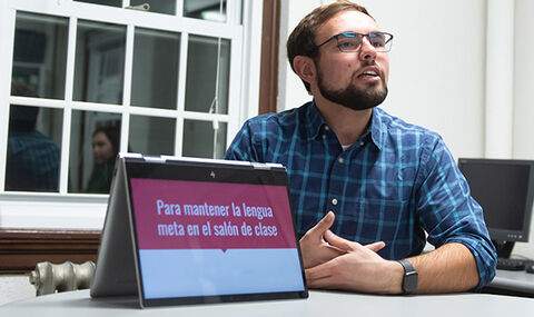 A BSU student giving a presentation in Spanish class showing the title in Spanish on his laptop