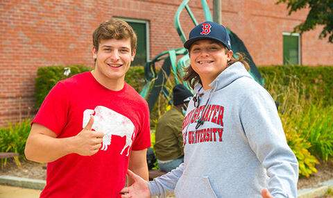 Two students pose for the camera; one gives a thumbs up