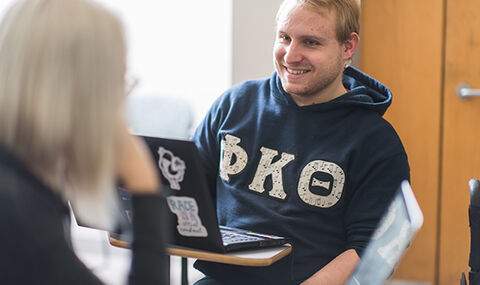 A BSU student smiles while talking with another student