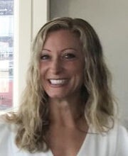 headshot photo of Amanda Barudin Carreiro smiling with long wavy dirty blonde hair wearing a v-neck white top